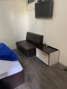 占西Hotel Abhishek的一间有床、沙发和电视的房间