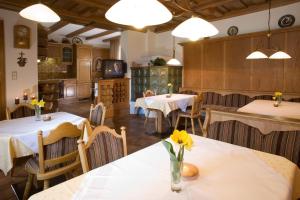 シュヴェンダウにあるGästehaus Rauchの花のテーブルと椅子が並ぶレストラン