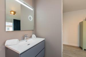 a bathroom with a white sink and a mirror at Welcome in - Duinweg 18 in Zoutelande +17 photos
