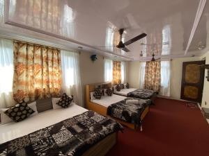 três camas num quarto com janelas e cortinas em Hotel Young Mamta em Srinagar