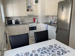 a kitchen with a refrigerator and a table with two chairs at Apartment Punakettu in Kokkola