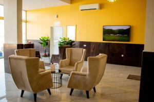 a waiting room with chairs and a tv on a wall at Qasayed Hotel فندق قصائد in Salalah