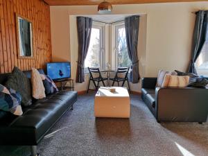 a living room with two couches and a table at Faodail, 1 Bed Studio apartment at Ravenscraig Castle and Park in Fife