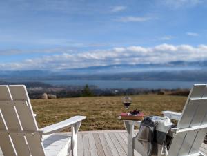 two white chairs and a table with a glass of wine at Autumn Lane, modern Farmhouse Style B&B with Stunning Lakeviews in West Kelowna