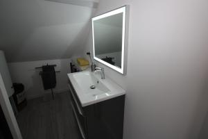 y baño con lavabo y espejo. en DU SEL A LA VIE, grand studio entre marais et océan, en Batz-sur-Mer