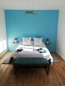 a bedroom with a blue wall and a large bed at La Fruitiere in Saints
