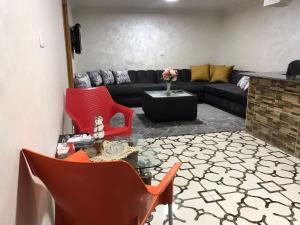 a living room with red chairs and a black couch at Apartment private entrance with terrace for rent close to services and city center in Amman