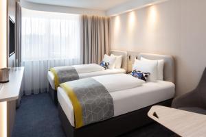 een hotelkamer met 2 bedden en een raam bij Holiday Inn Express - Aarburg - Oftringen, an IHG Hotel in Oftringen