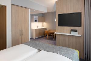 Cette chambre comprend un lit et une télévision à écran plat. dans l'établissement Holiday Inn Express - Aarburg - Oftringen, an IHG Hotel, à Oftringen