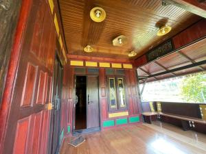 Cette chambre est dotée de murs en bois et de parquet. dans l'établissement โฮมสเตย์บ้านนายสิงโตเขาคูหา, à Ban Khu Ha Nai (1)