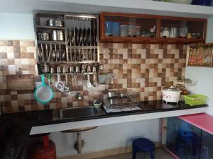 a kitchen with a sink and a counter with utensils at Yelagiri RAM Cottage @Home with kitchenette full in Yelagiri