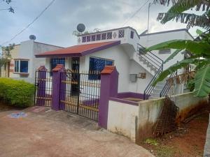 una casa con una puerta púrpura delante de ella en Yelagiri RAM Cottage @Home with kitchenette full en Yelagiri