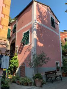 un bâtiment rose avec un banc à côté dans l'établissement La Casetta Rosa, à Monterosso al Mare