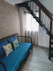 a bedroom with a blue bed with a metal ladder at La Casetta Rosa in Monterosso al Mare