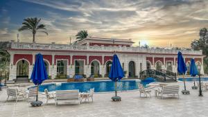 een resort met een zwembad, stoelen en parasols bij Helnan Palace Hotel - Adults Only in Alexandrië