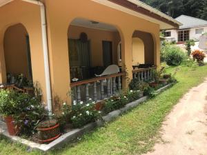 uma casa com uma varanda com plantas em A&D Holiday Home em Baie Sainte Anne