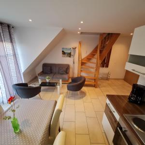 a living room with a couch and a staircase at Ferienwohnungen Saida Wohnung 12 in Norden