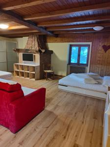 a bedroom with a large bed and a red couch at Maso Kofler in Rumo