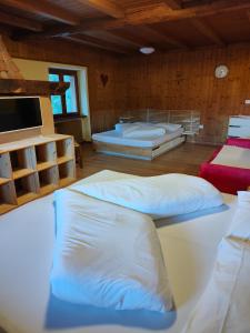 a room with two beds and a flat screen tv at Maso Kofler in Rumo