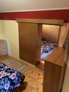 1 dormitorio con 2 camas y armario de madera en Vineyard Cottage Slanc, en Metlika