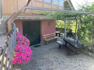 a patio with benches and flowers in front of a building at Vineyard Cottage Slanc in Metlika +3 photos