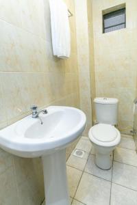 a bathroom with a white sink and a toilet at Kings Premier Inn in Nairobi