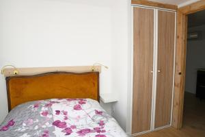 - une chambre avec un lit doté d'une tête de lit en bois et d'un placard dans l'établissement F2 RIGAUD, à Montpellier