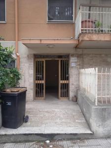 un ingresso a un edificio con un cestino di rifiuti di fronte di Casa Salvatore a Messina