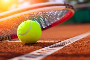 una pelota de tenis y raqueta en una pista de tenis en Campanile Conflans-Sainte-Honorine en Conflans-Sainte-Honorine