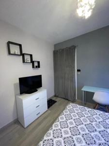- une chambre avec un lit, une télévision et un bureau dans l'établissement MAISON HELLO Charnay les Macon, à Charnay-lès-Mâcon