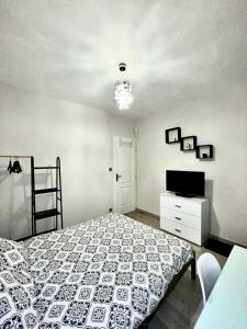 a bedroom with a bed and a dresser and a television at MAISON HELLO Charnay les Macon in Charnay-lès-Mâcon