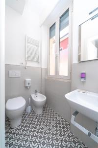 a white bathroom with a toilet and a sink at Seven Rooms in San Benedetto del Tronto