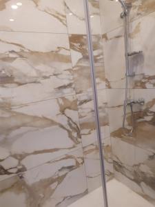 a shower in a bathroom with marble tiles at No. 31 in Valletta in Valletta