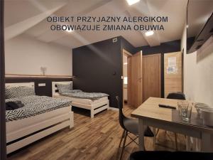 a room with two beds and a table with a tableablish at Widokowy Szczawnica in Szczawnica