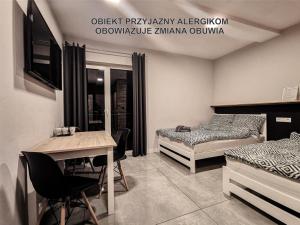 シュツァブニツァにあるWidokowy Szczawnicaのベッド2台、テーブル、デスクが備わる客室です。