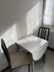 - une table blanche et une chaise dans la chambre dans l'établissement Le salinois, à Salins-les-Bains