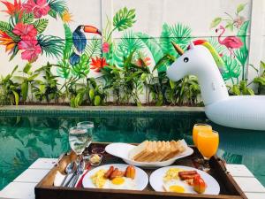 カトゥナーヤカにあるDouble Mango Villaのプールサイドのテーブルに朝食用の食材をトレイ