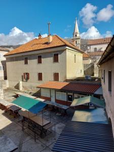 an outdoor patio with tables and a building at Mala placa in Senj