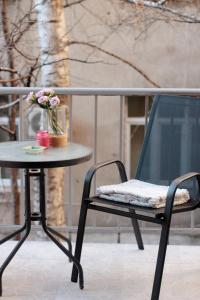 una mesa y una silla con un jarrón de flores en Apartments Aida, en Sarajevo