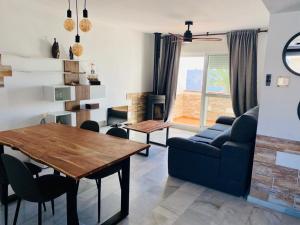 sala de estar con mesa y sofá en Encantador ático con chimenea y piscina en Almería, en Retamar