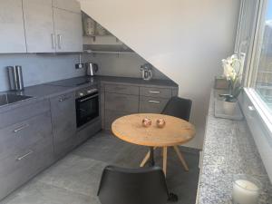 a small kitchen with a wooden table and chairs at Apartment Wendelsteinblick in Bad Aibling