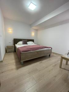 1 dormitorio con 1 cama y suelo de madera en Casa Zorilor, en Şugag