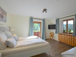 a bedroom with a bed with blue curtains and a window at Ferienwohnung Petra in Kössen