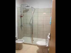 a bathroom with a shower and a toilet and a sink at Cabanas Penthouse Apartment in Cabanas de Tavira +21 photos
