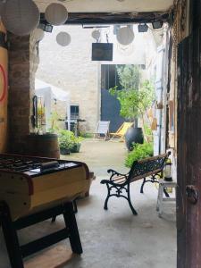 eine Terrasse mit 2 Bänken und einem Billardtisch in der Unterkunft Hôtes de Maïa Chambre d'hôtes in Moret-sur-Loing
