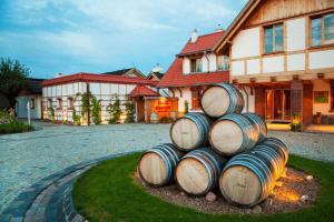 a stack of wine barrels in front of a house at Hotel Głęboczek Vine Resort& Spa in Wielki Głęboczek