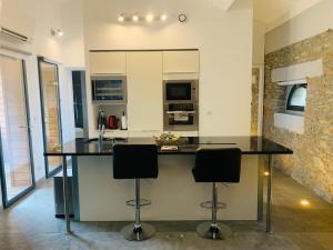 a kitchen with a counter and two bar stools at 45BB Apartment in Carcassonne