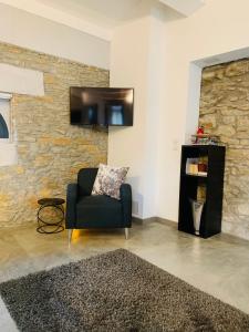 ein Wohnzimmer mit einem Stuhl und einem TV an der Wand in der Unterkunft 45BB Apartment in Carcassonne
