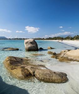 a beach with two large rocks in the water at Restaurant - Chambres d'Hôtes Terra Bella Lecci in Porto-Vecchio