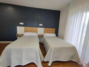 2 camas en una habitación con ventana en El Pino en Penagos
